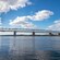 A bridge stretches across a body of water with hills in the background